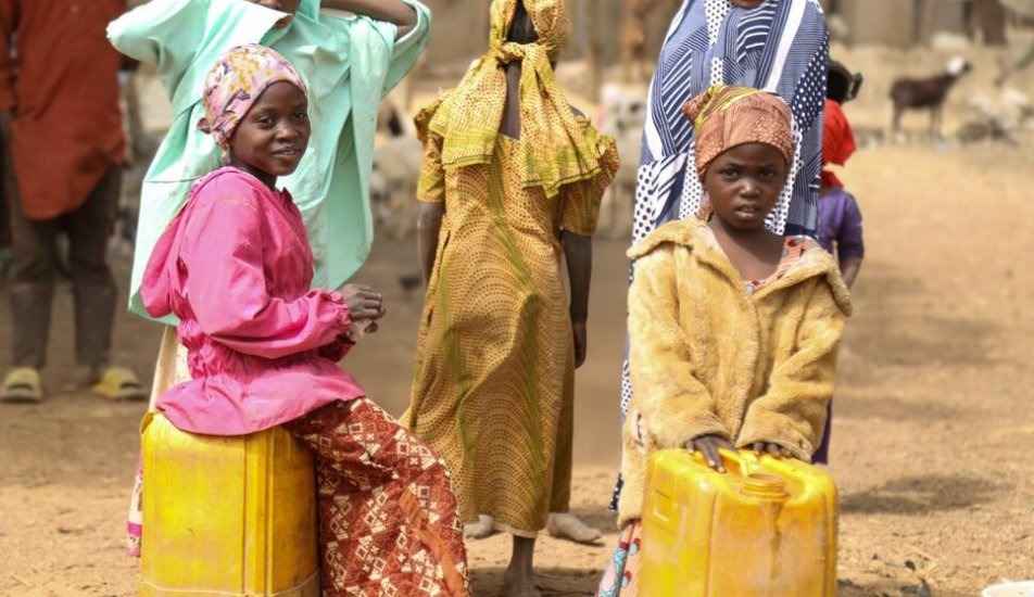 Girls carrying water jugs in rural Nigeria before borehole access