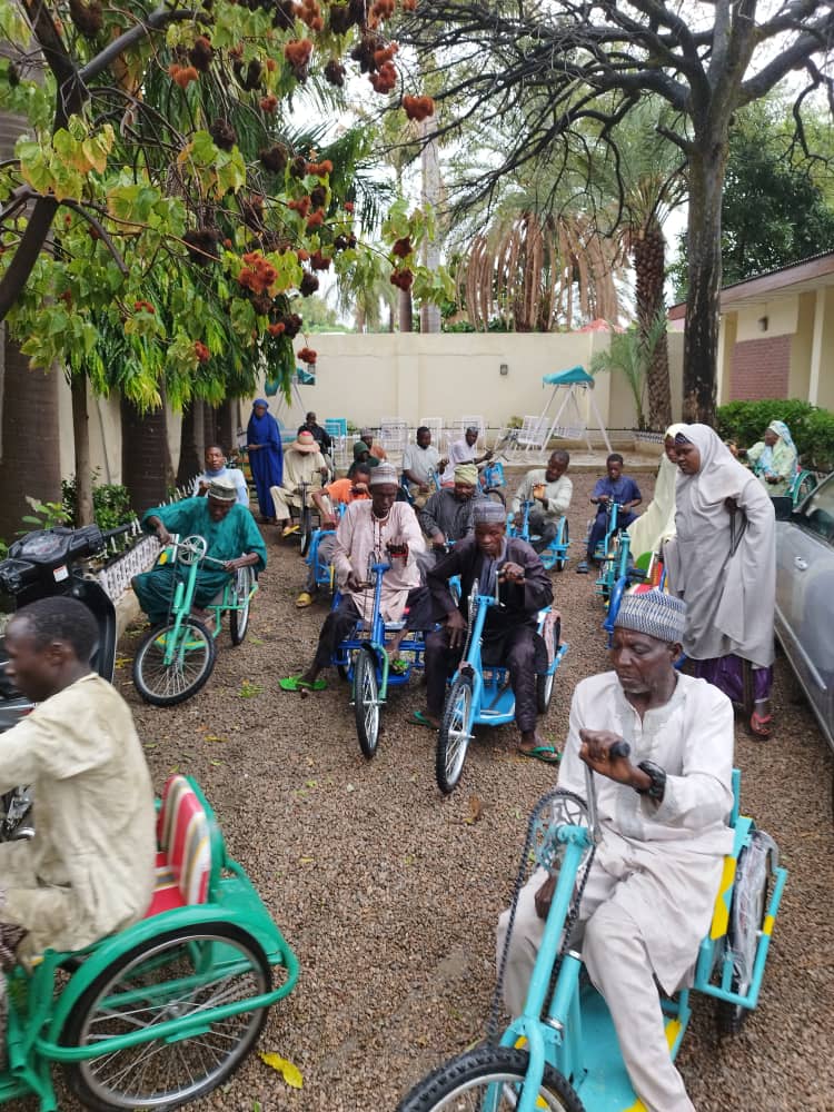 People with disabilities in Nigeria receiving hand-tricycles from WDBF